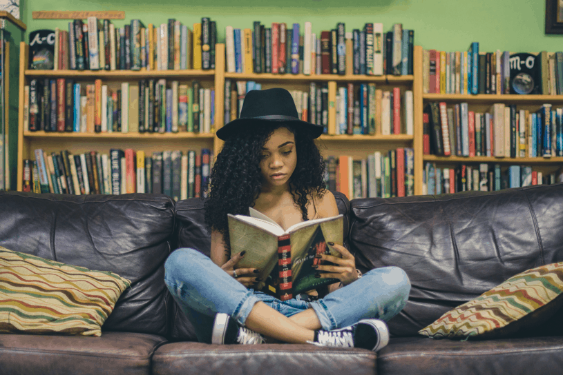 woman reading a book on couch; Photo by Seven Shooter from Unsplash